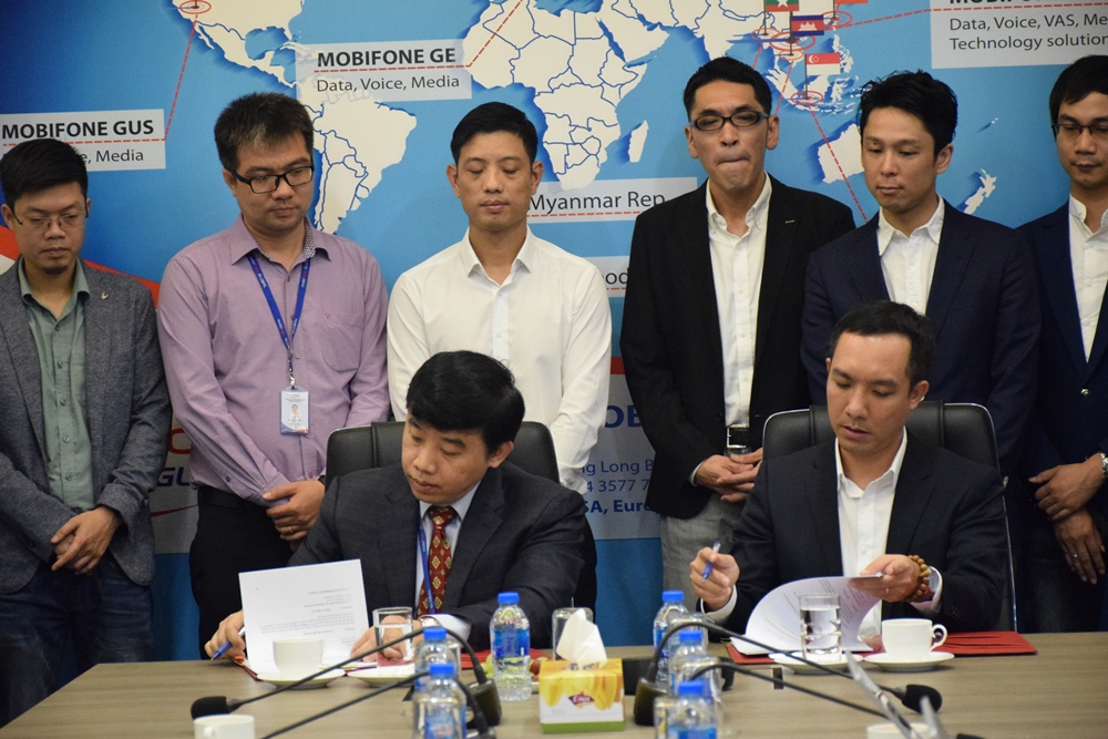 Ông Ngô Văn Tẩu (phải) – Giám đốc GMO-Z.com RUNSYSTEM và ông Vũ Phi Long (trái) – Tổng Giám đốc MobiFone Global đặt bút ký vào bản hợp đồng hợp tác