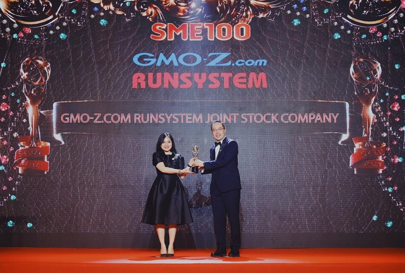 Đại diện GMO-Z.com RUNSYSTEM bước lên bục vinh danh nhận cúp kỷ niệm của Giải thưởng SME100 2022